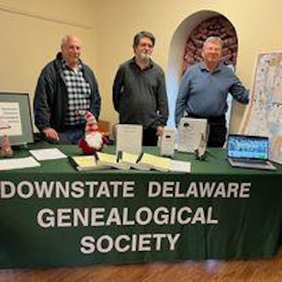 DDGS Outreach table and three members image 